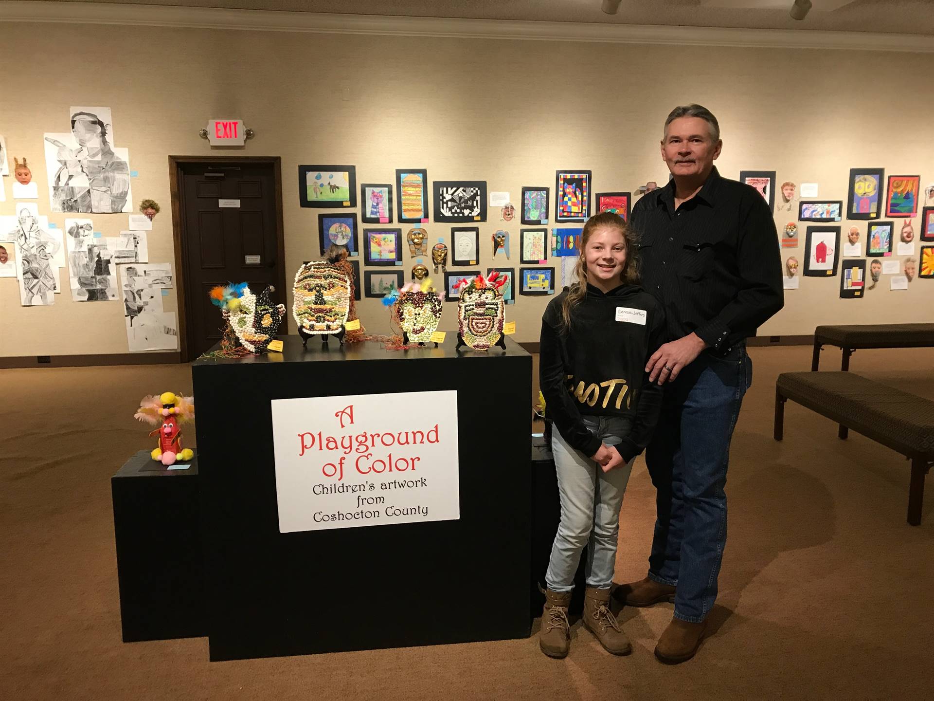Student and Parent in front of Art display.