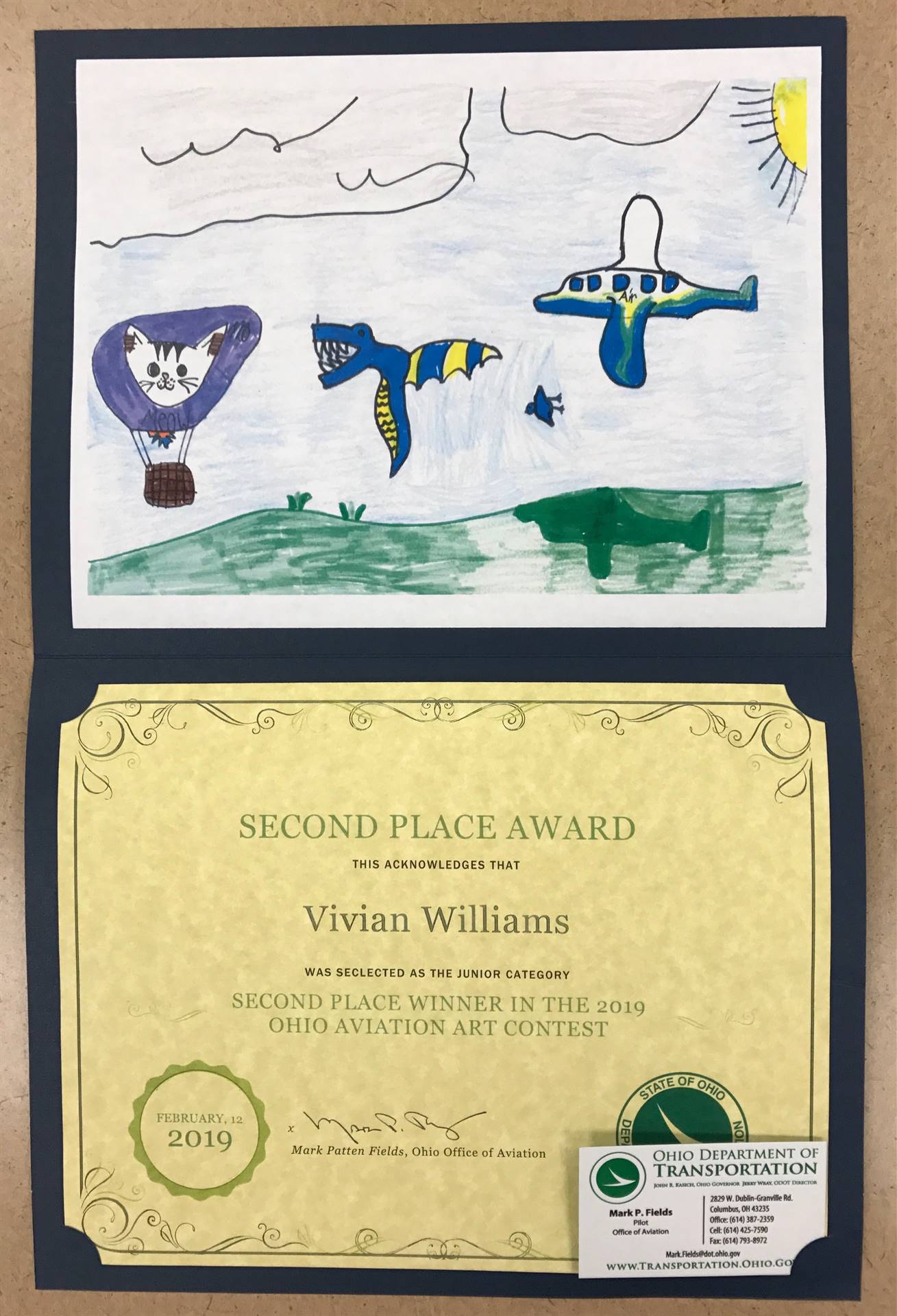 Student art display winner depicting a hot air balloon, a dragon and an airplane.