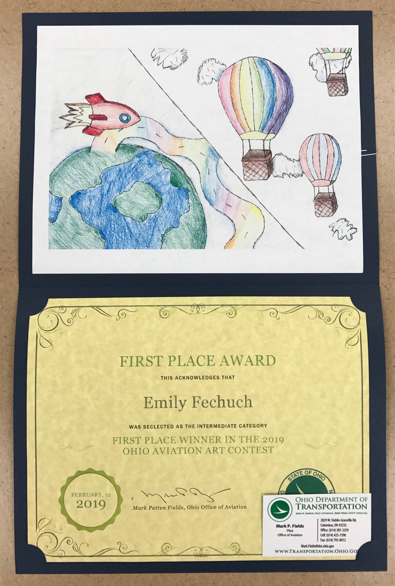 Student art display winner depicting earth, hot air balloons and rockets.