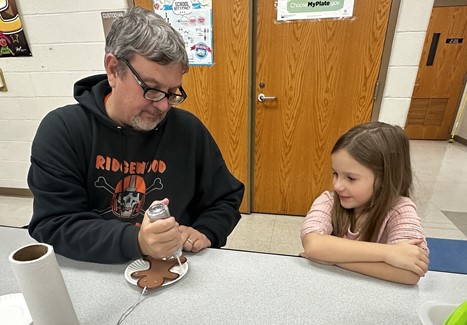 Superintendent and Student making Christmas ornaments