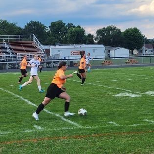 High School Girls Soccer team playing soccer on football field